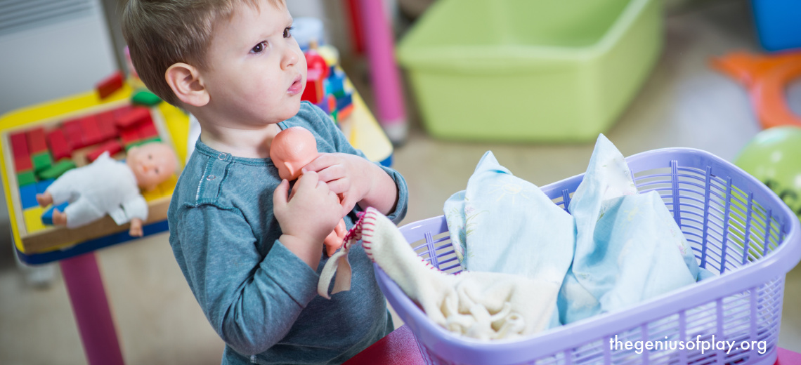 young boy toddler showing empathy taking care of a toy doll